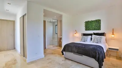 a bedroom with a large bed and a bathroom at Brand New Waterfront Villa with pool in Faro
