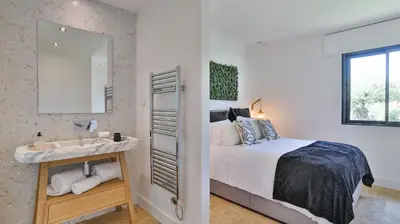 a bedroom with a bed and a sink and a mirror at Brand New Waterfront Villa with pool in Faro