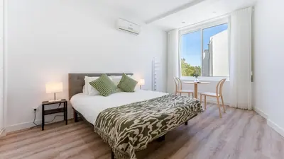 a bedroom with a bed and a table and a window at Modern Retreat 2 in Faro by Lovelystay in Faro