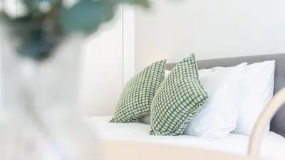 a bed with two green and white pillows on it at Modern Retreat 2 in Faro by Lovelystay in Faro