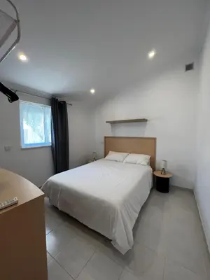 a bedroom with a large white bed and a window at O Limoeiro - 154949/AL in Faro