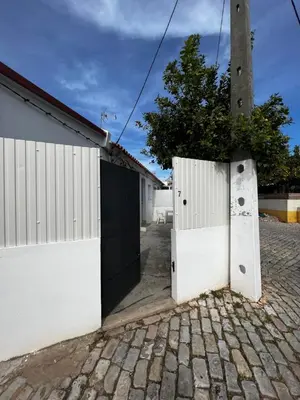 a white garage with a gate and a pole at O Limoeiro - 154949/AL in Faro