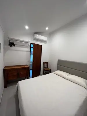 a bedroom with a white bed and a desk at O Limoeiro - 154949/AL in Faro