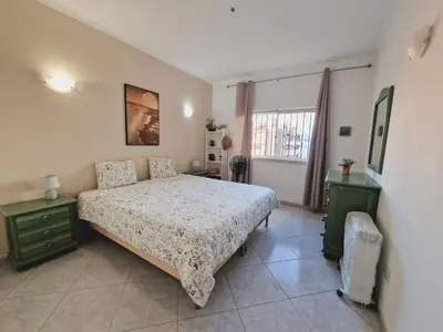 a bedroom with a bed and two lamps and a window at Casa Kari in Albufeira