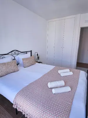 a bedroom with a large bed with two towels on it at Carmo City Center 2 in Faro