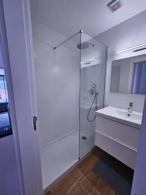 a white bathroom with a shower and a sink at Carmo City Center 2 in Faro