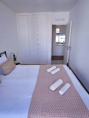 a bedroom with a bed with two white towels on it at Carmo City Center 2 in Faro