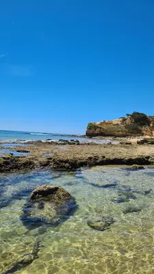 a group of rocks in the water on a beach at APARTAMENTOS CABRITA in Olhos de Água