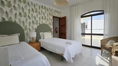 a hotel room with two beds and a window at Casa Catarina in Albufeira