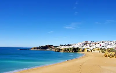a living room with a couch and a tv at BnB Homes Ocean view Apartment with comfortable Terrace, 2 Swimming pools & Tennis court in Albufeira