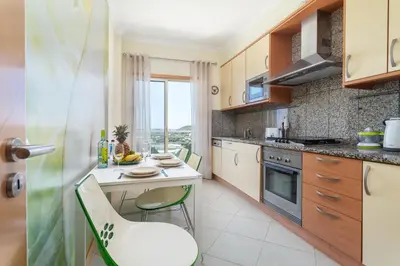 a bedroom with a bed and a large window at BnB Homes Ocean view Apartment with comfortable Terrace, 2 Swimming pools & Tennis court in Albufeira