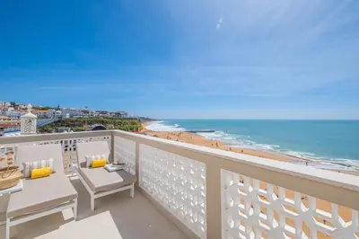 a balcony with chairs and a view of the beach at Casa na Muralha - Beach front - Rooftop Jacuzzi by DreamvillasAlbufeira in Albufeira