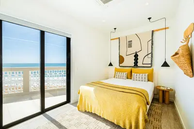 a bedroom with a bed with a view of the ocean at Casa na Muralha - Beach front - Rooftop Jacuzzi by DreamvillasAlbufeira in Albufeira