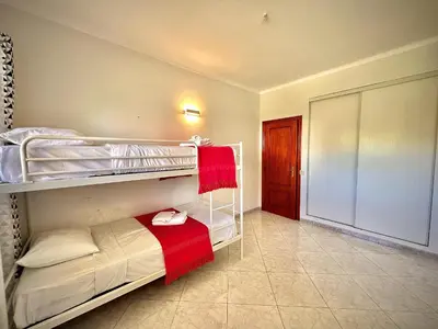 a bedroom with two bunk beds with a red towel at Albufeira Marina Sol With Pool by Homing in Albufeira
