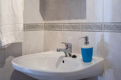 a bathroom sink with a blue glass on it at Blife Allya private rooms in Faro