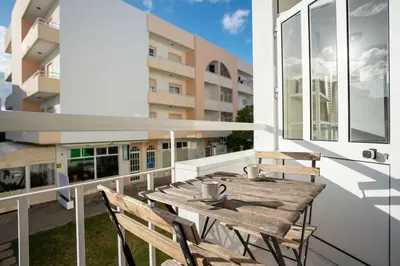a wooden table on the balcony of a building at Blife Allya private rooms in Faro