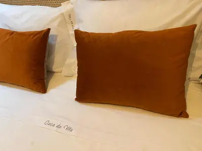 two brown pillows are sitting on a bed at Casa da vila in Faro
