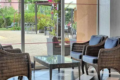 a group of chairs and a table with a dog in a patio at Estúdio Vista Mar em Vilamoura in Quarteira