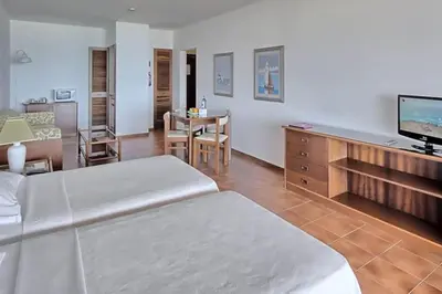 a room with a bed and a television and a table at Estúdio Vista Mar em Vilamoura in Quarteira