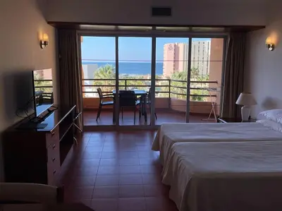 a hotel room with two beds and a view of the ocean at Estúdio Vista Mar em Vilamoura in Quarteira