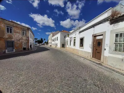 an empty street in a town with white buildings at Blife Castelya private rooms in Faro
