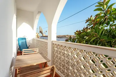 a balcony with a view of the ocean at Blife Faya private rooms in Faro