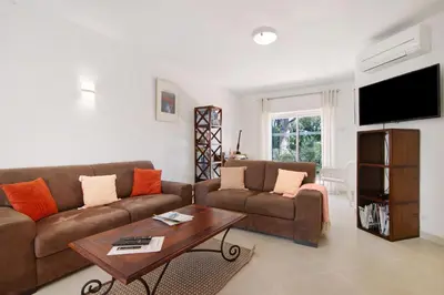 a living room with a couch and a table at Townhouse Ramas in Vale do Lobo