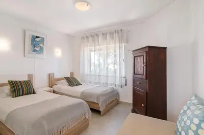 two beds in a room with a window at Townhouse Ramas in Vale do Lobo