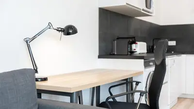 a desk in a kitchen with a lamp and chairs at Modern Retreat 1 in Faro by Lovelystay in Faro
