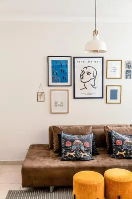 a living room with a brown couch and some pictures on the wall at Casa Gulbenkian - Modern apartment by HD in Faro
