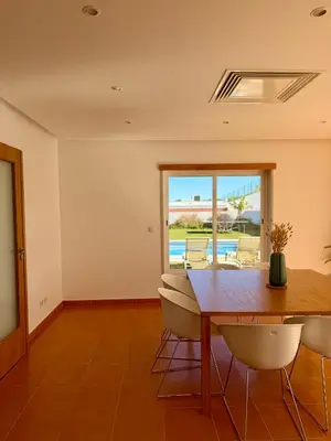 a kitchen with wooden cabinets and a sink at Vila Noélia in Albufeira