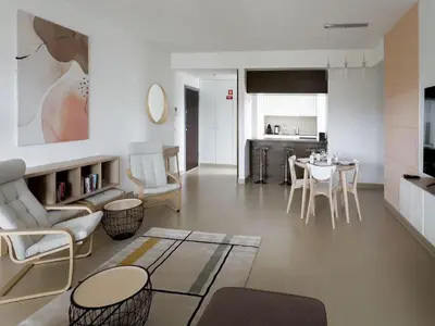 a living room with a table and chairs at Стильный апартамент Т2 Quarteira in Quarteira