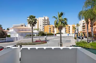 a view of a street with palm trees and buildings at Casa Sol in Quarteira