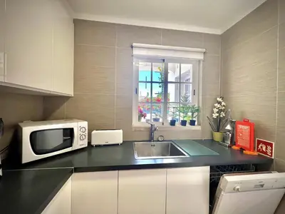 a small kitchen with a microwave and a sink at Vilamoura Eden Villa With Pool by Homing in Vilamoura