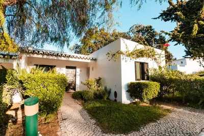 a white house with a garden and trees at Acolhedora Vila 371, 3 quartos, Balaia Golf Village in Albufeira
