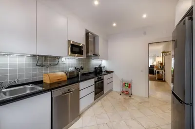 a kitchen with white cabinets and a sink at Vilamouratenis Wave by SAPvillas in Vilamoura