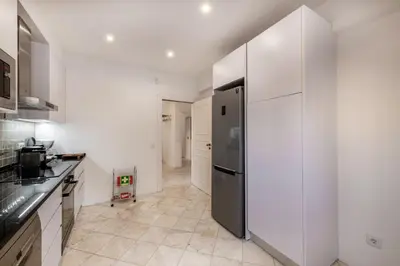 a kitchen with white walls and a stainless steel refrigerator at Vilamouratenis Wave by SAPvillas in Vilamoura