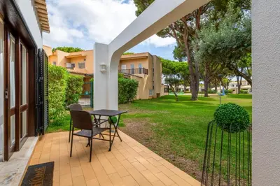 a patio with a table and chairs in a yard at Vilamouratenis Wave by SAPvillas in Vilamoura