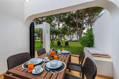 a wooden table and chairs on a patio at Vilamouratenis Wave by SAPvillas in Vilamoura