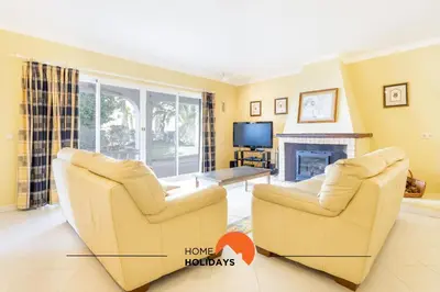 a living room with two chairs and a fireplace at #214 Vivenda 3 Quartos by Home Holidays in Albufeira