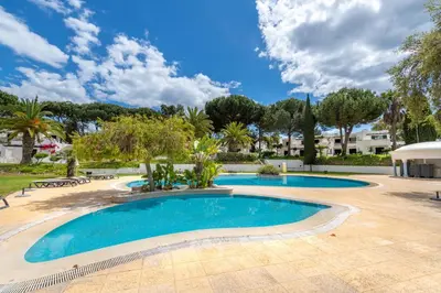 a large swimming pool in a yard with trees at Albufeira Balaia Golf Vilage 6 With Pool by Homing in Albufeira