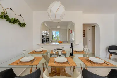 a dining room with a glass table and chairs at Albufeira Balaia Golf Vilage 6 With Pool by Homing in Albufeira