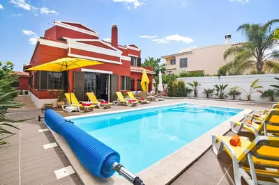 a swimming pool with a inflatable raft in front of a house at Sunshine House in Faro