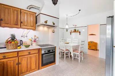 a kitchen with wooden cabinets and stainless steel appliances at Sunshine House in Faro