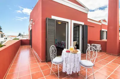 a white room with a bed with colorful pillows at Sunshine House in Faro