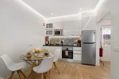 a kitchen with white cabinets and a stainless steel refrigerator at Luxury Sweet Homes T2 in Faro