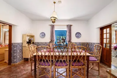 a dining room with a wooden table and chairs at Country House Casa Da Avó in Loulé