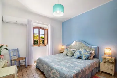 a blue bedroom with a bed and a window at Country House Casa Da Avó in Loulé