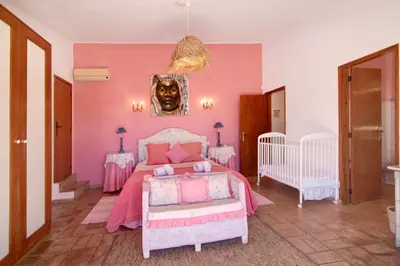 a pink bedroom with a bed and two tables at Country House Casa Da Avó in Loulé