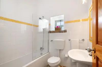 a white bathroom with a toilet and a sink at Country House Quinta da Ilda in Loulé